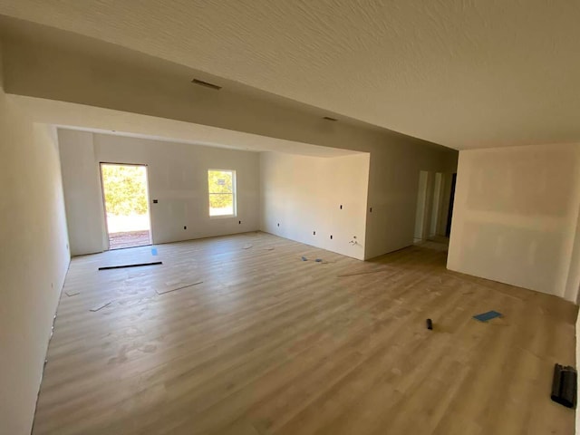 empty room with a textured ceiling and hardwood / wood-style flooring