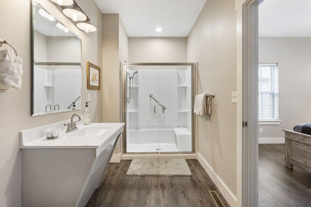 bathroom with a shower with door, hardwood / wood-style floors, and vanity