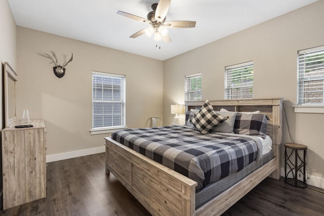 bedroom featuring ceiling fan, dark hardwood / wood-style flooring, and multiple windows