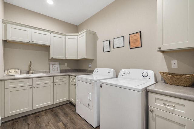 clothes washing area featuring cabinets, dark hardwood / wood-style floors, sink, and washing machine and dryer