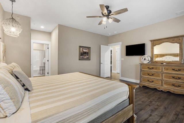 bedroom with ceiling fan with notable chandelier, dark wood-type flooring, and connected bathroom