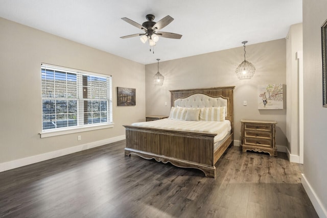 bedroom featuring ceiling fan with notable chandelier and dark hardwood / wood-style flooring