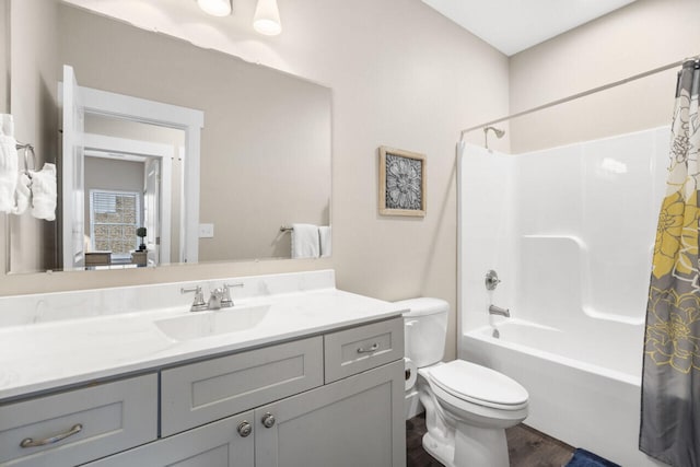 full bathroom featuring hardwood / wood-style floors, vanity, shower / bath combo with shower curtain, and toilet