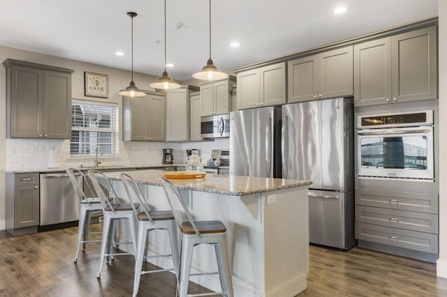 270 Chateau Cove Dr, Branson, MO 65616 - kitchen with a center island, light stone counters, tasteful backsplash, gray cabinets, and stainless steel appliances