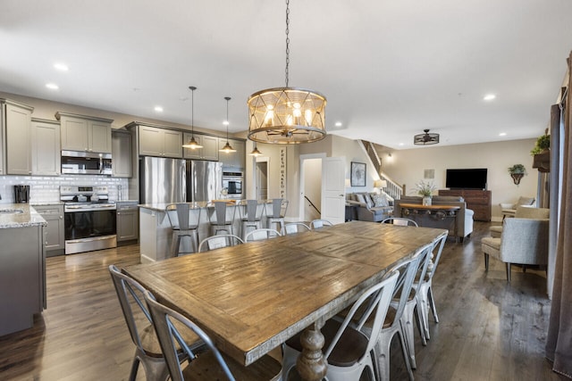 dining area with dark wood-type flooring and a chandelier