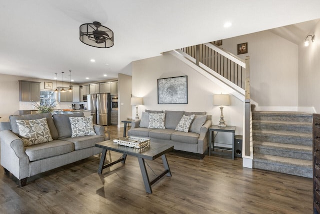 living room featuring dark wood-type flooring and ceiling fan