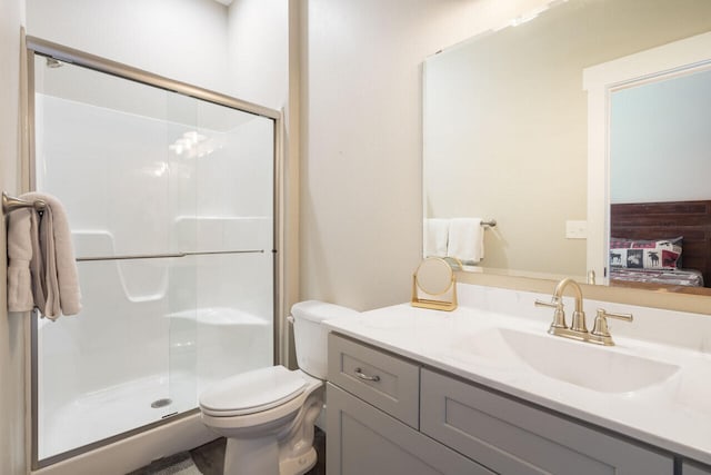 bathroom with vanity, toilet, and a shower with door