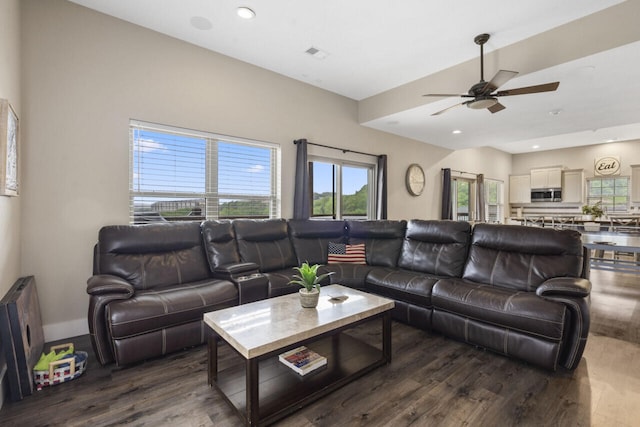 living room featuring ceiling fan and dark wood-type flooring