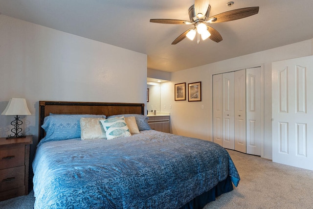 bedroom with ensuite bathroom, ceiling fan, and light colored carpet