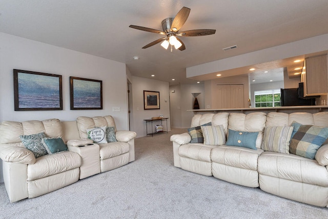 carpeted living room featuring ceiling fan