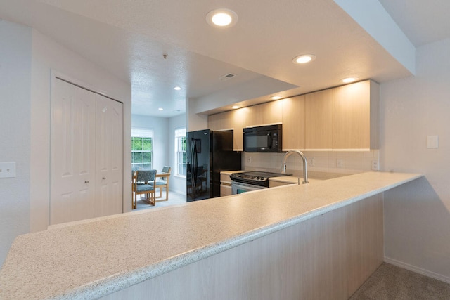 kitchen featuring black appliances, tasteful backsplash, sink, kitchen peninsula, and light colored carpet