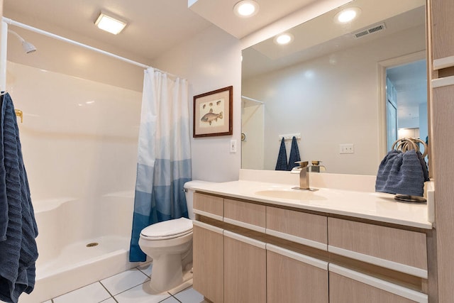 bathroom featuring toilet, vanity, tile patterned flooring, and walk in shower