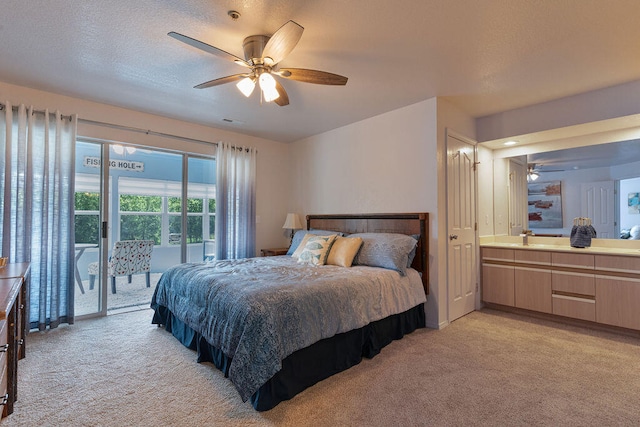 carpeted bedroom with ceiling fan, a textured ceiling, ensuite bath, and access to exterior