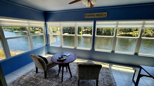 sunroom / solarium featuring a water view and ceiling fan