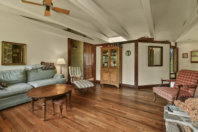 living area with a ceiling fan, dark wood-type flooring, and beamed ceiling