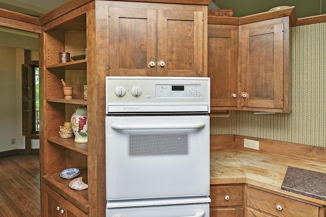 kitchen featuring open shelves, wood finished floors, a warming drawer, baseboards, and white oven