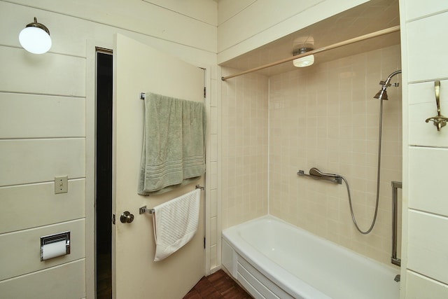 full bathroom featuring wood finished floors and bathing tub / shower combination