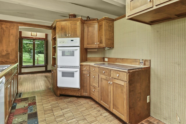kitchen with double oven, brown cabinetry, vaulted ceiling with beams, and dishwashing machine