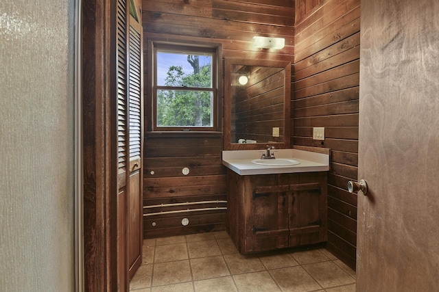 bathroom with tile patterned floors, wood walls, and vanity