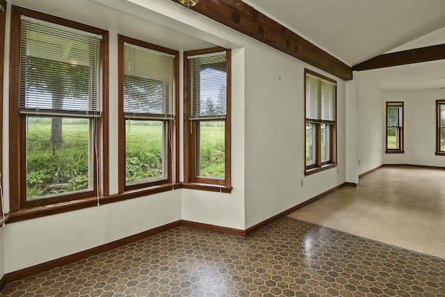 unfurnished room featuring dark floors, vaulted ceiling, and baseboards