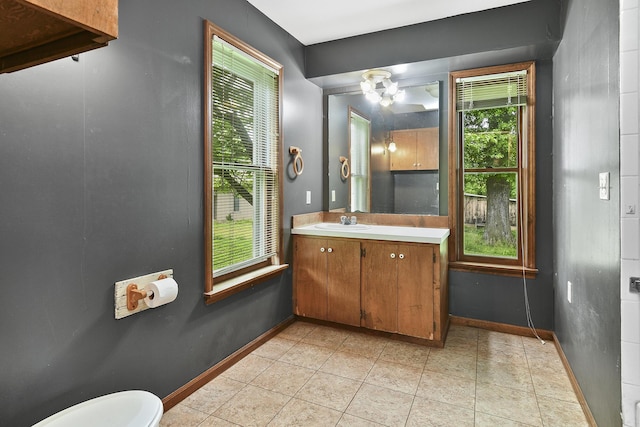 bathroom with tile patterned floors, baseboards, vanity, and toilet