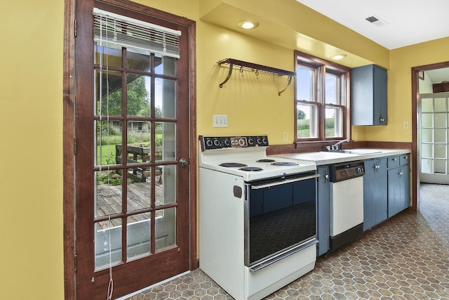 kitchen with visible vents, a sink, white appliances, and light countertops