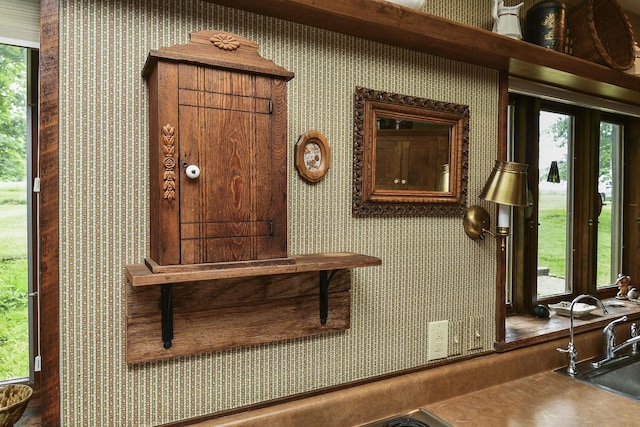 details featuring a sink and wallpapered walls