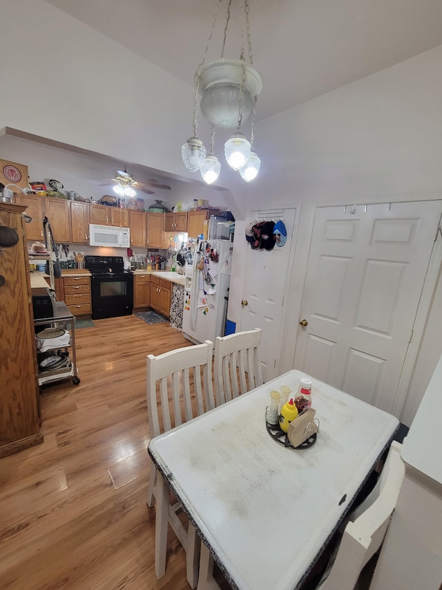 dining room featuring ceiling fan, light wood-type flooring, and sink