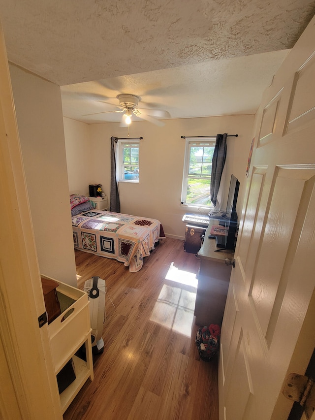 5317 E Ave, Morrisville, MO 65710 - bedroom featuring baseboards, a ceiling fan, wood finished floors, and a textured ceiling