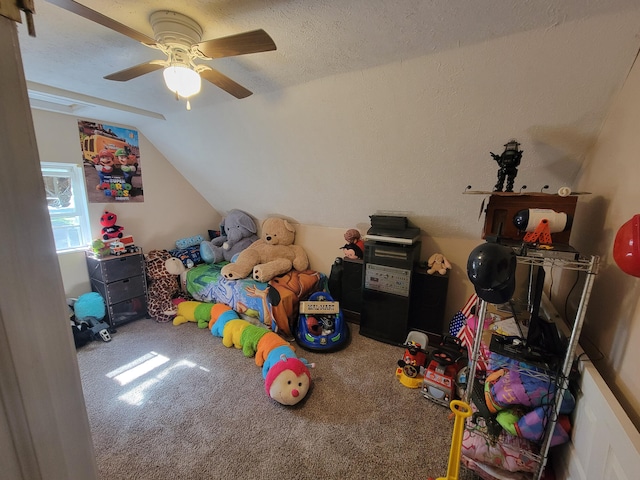 recreation room with carpet floors, lofted ceiling, a textured ceiling, and ceiling fan