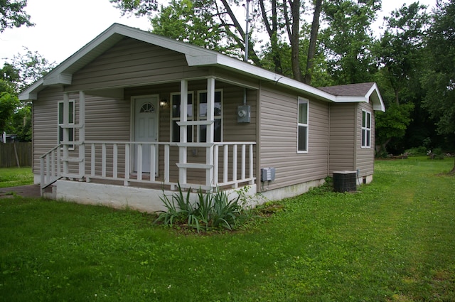 view of front of home featuring a front yard, a porch, and central air condition unit