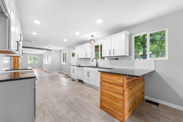 kitchen featuring white cabinets, sink, kitchen peninsula, light hardwood / wood-style flooring, and white dishwasher