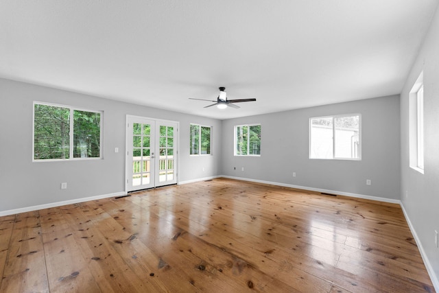 empty room featuring ceiling fan, french doors, and light hardwood / wood-style floors