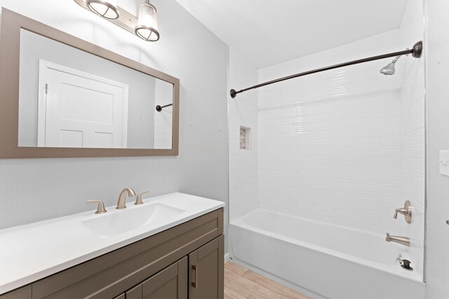 bathroom with tiled shower / bath, vanity, and hardwood / wood-style floors