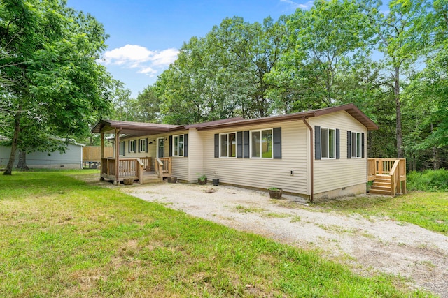 rear view of house featuring a yard and a wooden deck