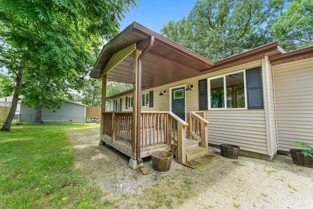 view of front of home with a wooden deck and a front lawn