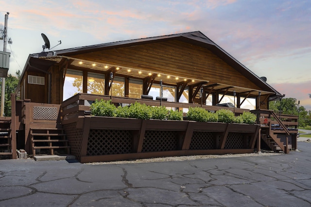 back house at dusk featuring a deck