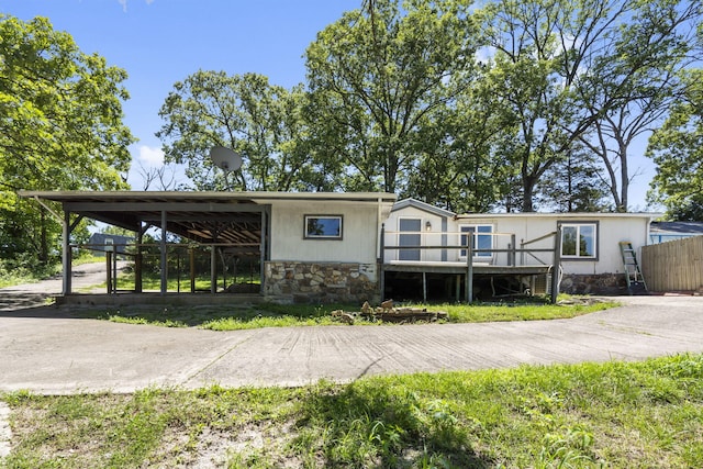 back of house with a carport and a deck