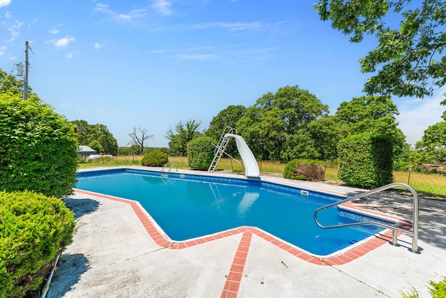 view of swimming pool with a patio and a water slide