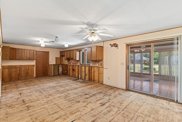 kitchen with light wood-type flooring, a textured ceiling, and ceiling fan