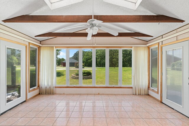 unfurnished sunroom with ceiling fan and vaulted ceiling with skylight