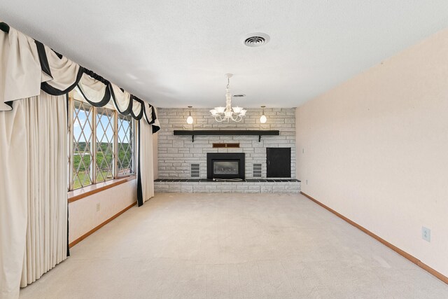 unfurnished living room featuring a brick fireplace, a notable chandelier, a textured ceiling, and light carpet