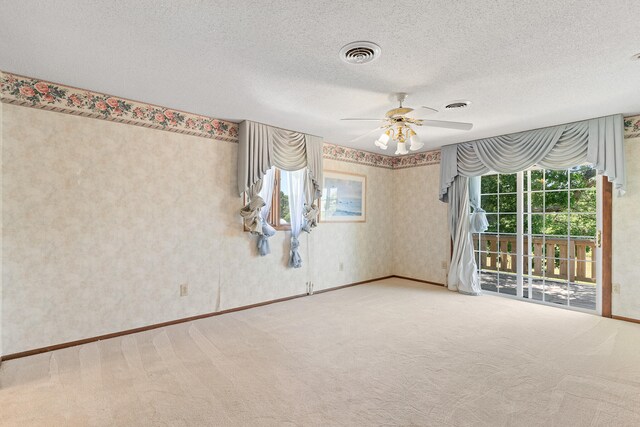 empty room with carpet floors, ceiling fan, and a textured ceiling