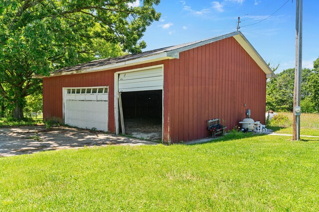 garage featuring wood walls and a lawn