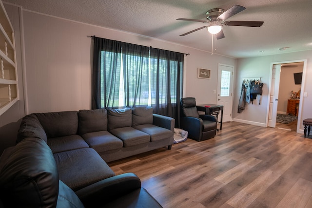 living room with wood-type flooring, ceiling fan, and a textured ceiling