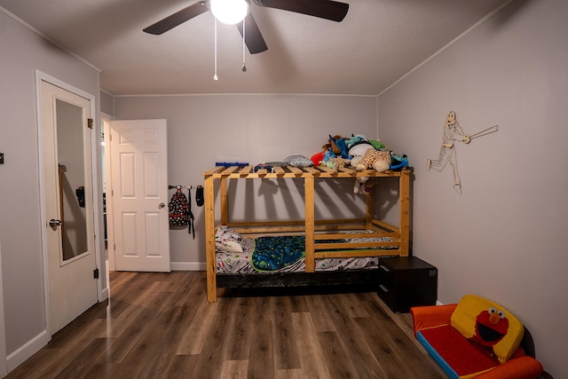 bedroom featuring ceiling fan, ornamental molding, a textured ceiling, and dark hardwood / wood-style flooring