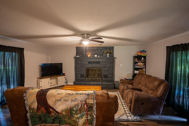 living room featuring a fireplace, wood-type flooring, and a textured ceiling