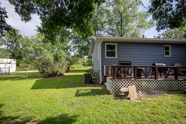 back of property featuring central AC, a lawn, and a wooden deck