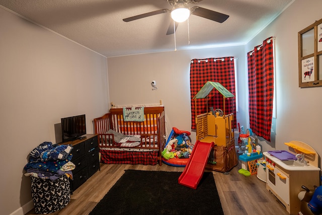 bedroom with hardwood / wood-style flooring, ceiling fan, and a textured ceiling