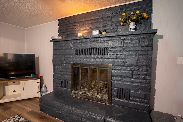 room details with hardwood / wood-style flooring, a fireplace, wood walls, and a textured ceiling